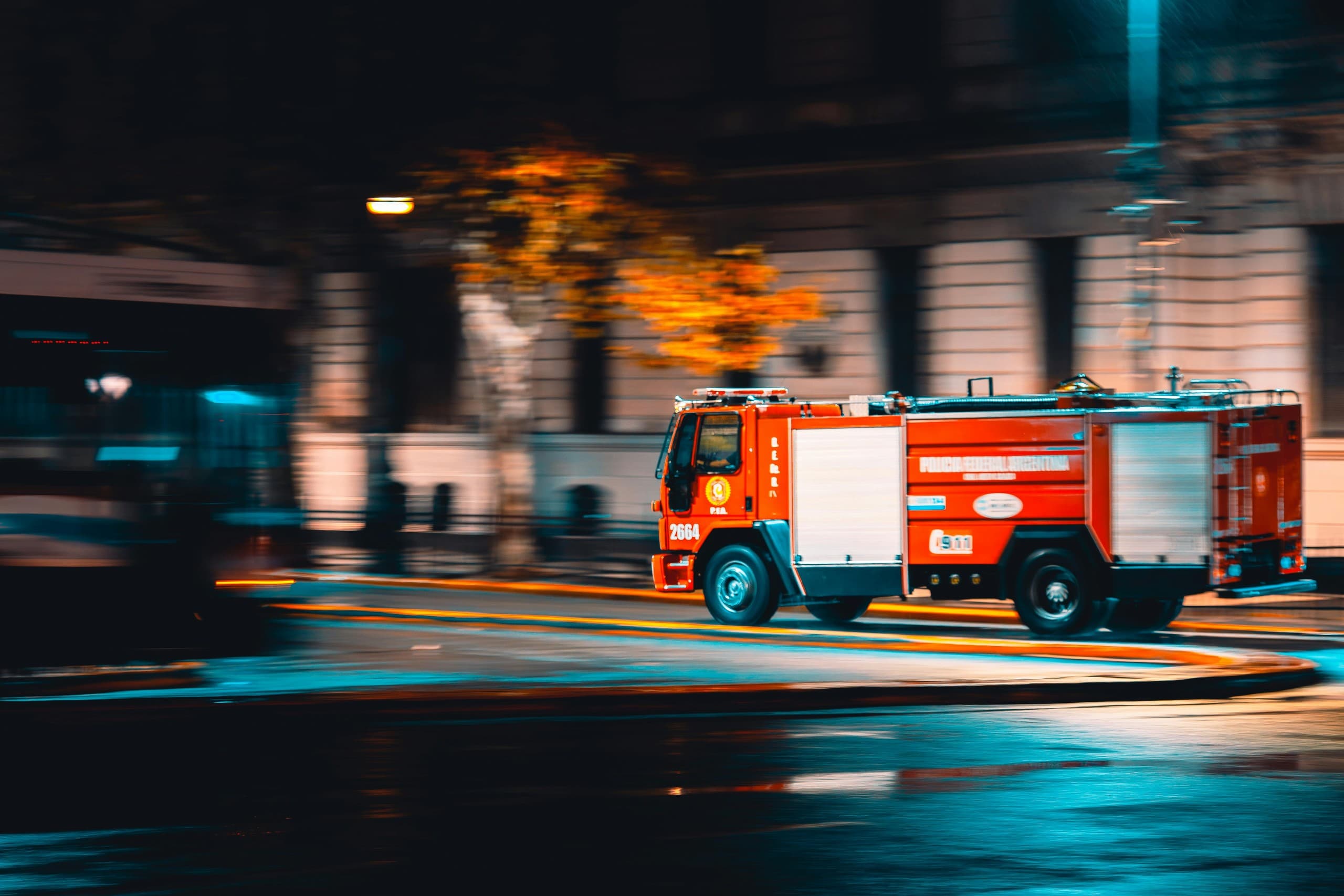 Fire engine responding through a city street at night